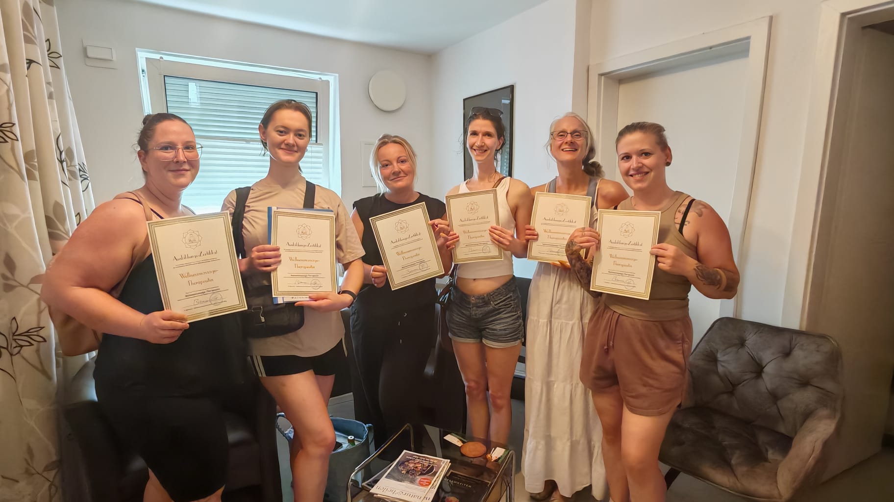 Sechs Teilnehmerinnen halten ihr Ausbildungs-Zertifikat zur Wellnessmassage-Therapeutin nach dem Massagekurs der Massageschule Baumann in Aalen