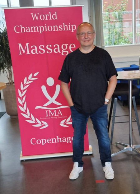 Peter Baumann vor dem World Championship Massage Banner in Kopenhagen 2022